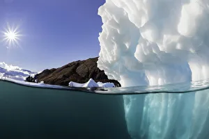 <b class=qtipBold><figcaption>Sunlight On An Iceberg</figcaption></b><br>Sunlight on this iceberg has made the older blue ice glow. Scoresbysund Fjord, eastern Greenland. Red Island can be seen in the background.<br><em>© 2016 Wildestanimal</em> Sunlight On An Iceberg