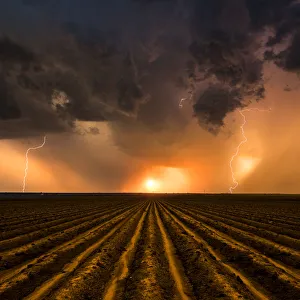 Sunset Thunderstorm over a ploughed field, Nebraska. USA Sunset Thunderstorm over a ploughed field, Nebraska. USA