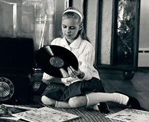 Record Collection: Teen girl with vinyl records and record player, sitting on floor
