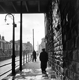 Tiger Bay; A man walking under a railway bridge in the dockland area of Cardiff Tiger Bay; A man walking under a railway bridge in the dockland area of Cardiff