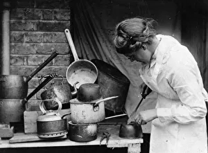 <b class=qtipBold><figcaption>Tinkering</figcaption></b><br>circa 1930: A woman mending pots and pans. (Photo by Hulton Archive/Getty Images) Tinkering