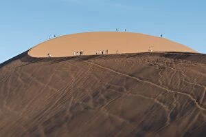 Southern Hemisphere Gallery: Tourists walking on the top of the famous Dune 45 sand dune. Sossuvlei, Namibia