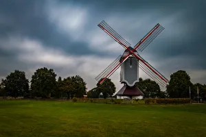 Traditional wind mill in Lomel, Belgium, with clouds and grass field, long exposure Traditional wind mill in Lomel, Belgium, with clouds and grass field, long exposure