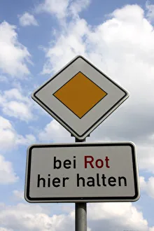 Traffic sign, priority road, stop here at red light Traffic sign, priority road, stop here at red light