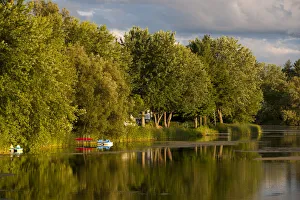 Trees and boats on Yamaska River in evening light with threatening clouds, Waterloo Trees and boats on Yamaska River in evening light with threatening clouds, Waterloo