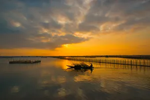 Vietnam - Fisherman go fishing on boat near net system on Tam Giang lagoon, Hue Vietnam - Fisherman go fishing on boat near net system on Tam Giang lagoon, Hue