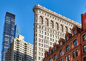 Side view of the Flatiron Building with surrounding buildings in the background against Side view of the Flatiron Building with surrounding buildings in the background against
