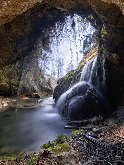 Waterfall view from inside a cave in a forest Waterfall view from inside a cave in a forest
