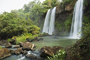 Three waterfalls in tropical landscape with flowers in foreground Three waterfalls in tropical landscape with flowers in foreground