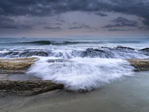 Wave jumping rocks in storms at sea at dawn Wave jumping rocks in storms at sea at dawn