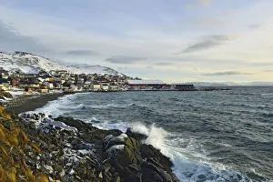 Waves in a rocky bay, buildings of the Honningsvag settlement at the back, Mageroya island, Finnmark County, Norway Waves in a rocky bay, buildings of the Honningsvag settlement at the back, Mageroya island, Finnmark County, Norway