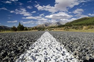 White road markings on a road with coarse asphalt, worms eye view, Arthurs Pass Road White road markings on a road with coarse asphalt, worms eye view, Arthurs Pass Road