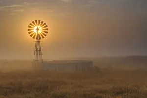 Windmill Backlit at Sunrise in the Mist and Fog of a Cold Winter Morning Windmill Backlit at Sunrise in the Mist and Fog of a Cold Winter Morning
