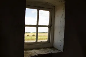 A window looks out from the Tracey Arms Drainage Mill over the River Bure and the A window looks out from the Tracey Arms Drainage Mill over the River Bure and the