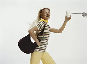 Woman with handbag holding glass of milk, close-up