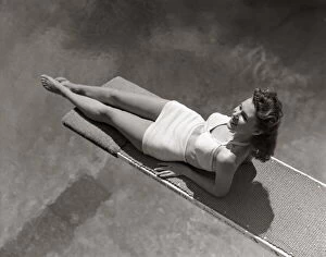 Sports Venue Gallery: Woman Lying On Diving Board Over Pool Sunbathing Two Piece Bathing Suit Summer