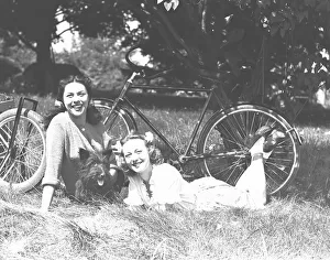 Two women and dog resting on grass, (B&W) Two women and dog resting on grass, (B&W)