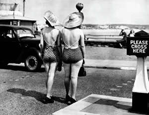 <b class=qtipBold><figcaption>Women In Swimwear</figcaption></b><br>Two women cross the road to the beach in Porthcawl, South Wales. Women In Swimwear