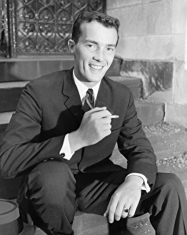 Young businessman sitting on steps, smoking cigarette, (B&W) Young businessman sitting on steps, smoking cigarette, (B&W)