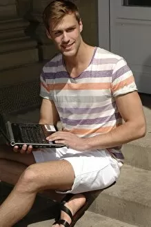 Dirty Gallery: Young man with laptop sitting on steps