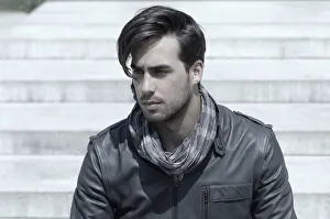 Young man wearing a leather jacket in front of an open staircase, portrait Young man wearing a leather jacket in front of an open staircase, portrait