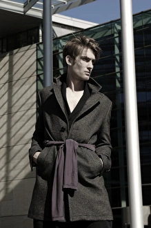 Young man wearing an overcoat in front of modern architecture, fashion shoot Young man wearing an overcoat in front of modern architecture, fashion shoot