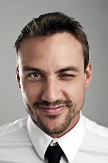 Young man wearing a shirt and a tie, blinking an eye, portrait Young man wearing a shirt and a tie, blinking an eye, portrait