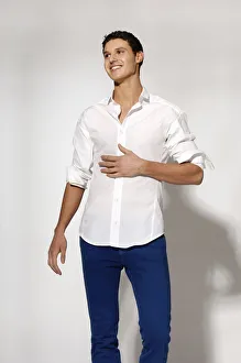 Young man in white shirt and blue jeans in movement Young man in white shirt and blue jeans in movement