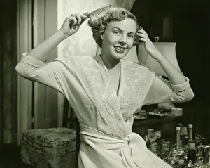 Young woman brushing hair, at home, (B&W), portrait Young woman brushing hair, at home, (B&W), portrait