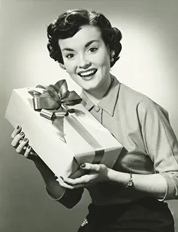 Young woman holding present, (B&W), portrait Young woman holding present, (B&W), portrait