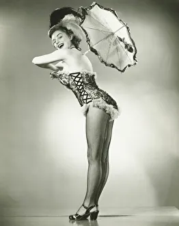 Young woman holding umbrella posing in studio, (B&W) Young woman holding umbrella posing in studio, (B&W)