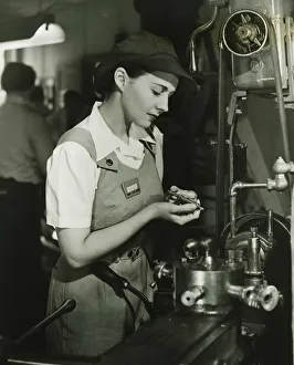 Young woman in overalls working by lathe in factory, (B&W) Young woman in overalls working by lathe in factory, (B&W)