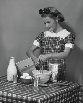 <b class=qtipBold><figcaption>Young woman preparing food</figcaption></b><br>UNITED STATES - CIRCA 1950s: Young woman preparing food.<br><em>© George Marks</em> Young woman preparing food