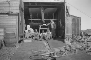 Party sitting in sun, beside the hangar door Party sitting in sun, beside the hangar door