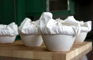 A batch of traditional English Christmas puddings, with cloths tied ready to steam A batch of traditional English Christmas puddings, with cloths tied ready to steam