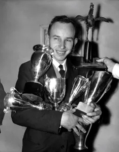 British Motorcycle World Champion John Surtees has both arms full of trophies already British Motorcycle World Champion John Surtees has both arms full of trophies already