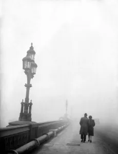 Couple walking across a bridge in London in fog 1950s love couple romance romantic Couple walking across a bridge in London in fog 1950s love couple romance romantic