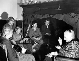 A group of elderly people and their dogs gathered together in a house in Sussex, England