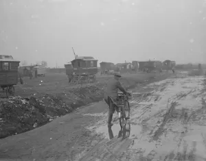 Caravan Prints: A cyclist on a muddy road with gypsy caravans, 1936 print