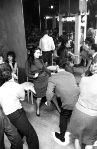 A mirror reflects the patrons in a night club dancing the twist dance / dancing / A mirror reflects the patrons in a night club dancing the twist dance / dancing /