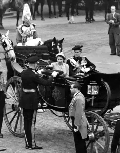 The queen, wearing pale green hat to match her collarless coat which she wore over The queen, wearing pale green hat to match her collarless coat which she wore over