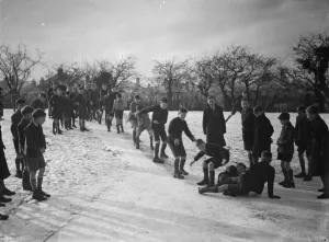 Schoolboys sliding on the snow on a path in Orpington, Kent. 1937 Schoolboys sliding on the snow on a path in Orpington, Kent. 1937