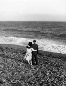Young couple with their arms round each other enjoing the seaside Young couple with their arms round each other enjoing the seaside