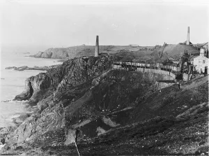 Prints of A wide general view of Levant Mine with the head gear of skip shaft and the winding engine house in the forgeround on the right. On the left standing above the cliffs is the arsenic stack United Kingdom Prints: Levant Mine Print, Early 1900s General View