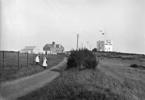 Prints of Lloyds signal station with flags flying and a view of the adjoining buildings. Two little girls stand on the approach road. Photographer: Probably Arthur William Jordan Cornwall Prints: Print of Bass Point Lloyds Signal Station, The Lizard, Cornwall