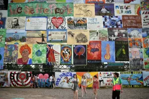 Prints of Revellers walk past an array of political and environmentally themed posters at the Glastonbury Festival of Music and Performing Arts on Worthy Farm near the village of Pilton in Somerset Music Prints: Glastonbury Festival Print 2015