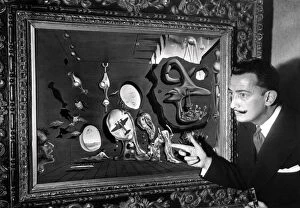Salvador Dali poses in front of one his paintings