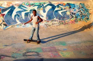 A young boy skateboards past a ramp decorated with graffiti in a skate park in Durban A young boy skateboards past a ramp decorated with graffiti in a skate park in Durban