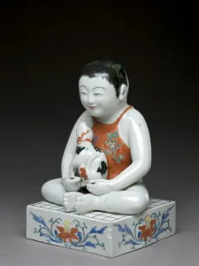 Boy with a dog sitting on a square shogi table, Kakiemon related ware, Japanese Boy with a dog sitting on a square shogi table, Kakiemon related ware, Japanese