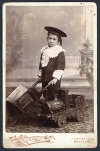 Boy with a toy train and wheelbarrow (b/w photo) Boy with a toy train and wheelbarrow (b/w photo)